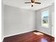 Bright bedroom featuring hardwood floors, neutral walls, a ceiling fan, and a window with view to outdoors at 1610 S F St, Elwood, IN 46036