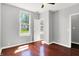 Bright bedroom featuring hardwood floors, neutral walls, a ceiling fan, and a view to the outdoors at 1610 S F St, Elwood, IN 46036