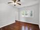 Bright living room featuring hardwood floors, neutral walls, multiple windows, and a ceiling fan at 1610 S F St, Elwood, IN 46036