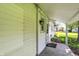 Covered porch with concrete floor on the side of the house with a single outdoor light at 1610 S F St, Elwood, IN 46036