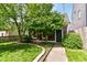 A backyard with a green lush tree, a walkway, an outdoor house, and a green bush at 1630 N New Jersey St, Indianapolis, IN 46202
