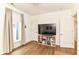 Bedroom with hardwood floors, large window with curtains and TV on top of bookshelf at 1630 N New Jersey St, Indianapolis, IN 46202