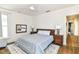Bright bedroom featuring a bed with patterned blue cover, hardwood floors, and a view into an adjacent room at 1630 N New Jersey St, Indianapolis, IN 46202
