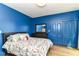 Bright blue bedroom with hardwood floors and a closet at 1630 N New Jersey St, Indianapolis, IN 46202