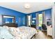 Blue bedroom featuring hardwood floors, two windows, and a dedicated desk area at 1630 N New Jersey St, Indianapolis, IN 46202