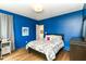 Bright blue bedroom with hardwood floors and a decorative floral comforter at 1630 N New Jersey St, Indianapolis, IN 46202