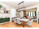Open-concept dining area featuring a modern light fixture, shelving, and a marble table with velvet chairs at 1630 N New Jersey St, Indianapolis, IN 46202