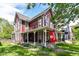 Two-story red home with a covered porch, green lawn, and an Indiana University flag on display at 1630 N New Jersey St, Indianapolis, IN 46202
