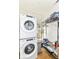 Bright laundry room with stacked washer and dryer and an organized storage shelf at 1630 N New Jersey St, Indianapolis, IN 46202