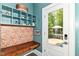 Cozy mudroom with a built-in bench, colorful patterned wall, and access to the backyard patio at 1630 N New Jersey St, Indianapolis, IN 46202