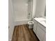 Bathroom featuring wood-look flooring, white cabinets, and a shower and tub combination at 1679 W 171St St, Westfield, IN 46074