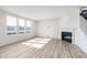Bright living room featuring a fireplace, hard surface floors, three windows, and white walls at 18943 Seaforth Way, Westfield, IN 46074