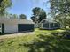 Enjoy a spacious, grassy backyard featuring a detached garage and a charming home under a clear blue sky at 2009 Draper St, Indianapolis, IN 46203
