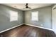 Empty bedroom with hardwood floors, neutral colored walls, a ceiling fan and windows at 2009 Draper St, Indianapolis, IN 46203