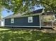Charming home exterior featuring dark siding, a covered porch, and a well-maintained lawn at 2009 Draper St, Indianapolis, IN 46203