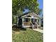 Inviting home with a cozy front porch and a bright yellow door at 2009 Draper St, Indianapolis, IN 46203
