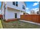 New white siding and stained wood deck feature this home's back exterior, complemented by a privacy fence at 2013 Yandes St, Indianapolis, IN 46202