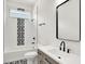 Bathroom featuring modern fixtures, a decorative tile accent, and a bathtub and shower combination at 2013 Yandes St, Indianapolis, IN 46202