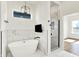 Bright bathroom with tub, shower, black hardware, and a mounted TV at 2013 Yandes St, Indianapolis, IN 46202