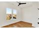 Bright bedroom featuring hardwood floors, ceiling fan, and double windows with a neighborhood view at 2013 Yandes St, Indianapolis, IN 46202