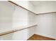 Bright walk-in closet featuring wood floors, a built-in shelf, and wood rails at 2013 Yandes St, Indianapolis, IN 46202
