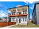 Modern two-story home featuring dual balconies, contemporary design, and a freshly landscaped yard under a bright blue sky at 2013 Yandes St, Indianapolis, IN 46202