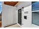 Close-up of a modern entrance featuring a black front door, stylish lighting, and the house number 1020 on white siding at 2013 Yandes St, Indianapolis, IN 46202