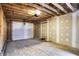 Garage features exposed wood framing, a concrete floor, and a white garage door at 2013 Yandes St, Indianapolis, IN 46202