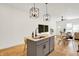 Open-concept kitchen featuring white cabinets, stainless steel appliances, island with sink, and dining area at 2013 Yandes St, Indianapolis, IN 46202