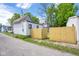 Exterior view of a white home with a newly installed wooden fence, enhancing privacy and curb appeal at 207 S Center St, Plainfield, IN 46168
