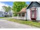 Charming home with a covered porch, red window detail, and a lush green lawn at 207 S Center St, Plainfield, IN 46168