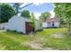 View of the back of the property, including the garage with a red door and grassy yard at 207 S Center St, Plainfield, IN 46168