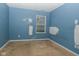 A blue bedroom featuring a window for natural light with patched walls at 2416 Foxtail Dr, Plainfield, IN 46168