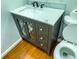 Bathroom includes vanity with storage and a toilet, accentuated by wood flooring at 2435 Asbury St, Indianapolis, IN 46203
