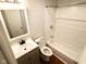 Bathroom features a vanity with sink, toilet, and tiled tub and shower combo at 2435 Asbury St, Indianapolis, IN 46203