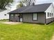 Charming one-story home featuring manicured lawn, gray siding, and black trim at 2435 Asbury St, Indianapolis, IN 46203