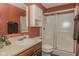 Full bathroom featuring rust colored walls, vanity sink, toilet, and shower with glass doors at 270 Rapid Rill Ln, Brownsburg, IN 46112