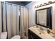 Traditional bathroom with neutral colors, curtained shower, and dark-framed mirror at 3510 E 34Th St, Indianapolis, IN 46218