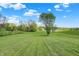 Well-maintained lawn with trees creating a beautiful landscape on a sunny day at 3682 S 380 E, Anderson, IN 46017
