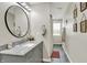 A stylish bathroom featuring gray cabinetry, a round mirror, and unique botanical artwork at 3682 S 380 E, Anderson, IN 46017