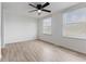 Bright bedroom with wood-look vinyl flooring, white walls, ceiling fan, and two windows at 3705 Lima Ct, Indianapolis, IN 46227