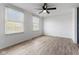 Bright bedroom with wood-look vinyl flooring, white walls, ceiling fan, and two windows at 3705 Lima Ct, Indianapolis, IN 46227