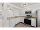 Bright kitchen featuring white cabinetry, stainless steel appliances, and an open layout with wood-look vinyl flooring at 3705 Lima Ct, Indianapolis, IN 46227