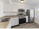 Bright kitchen featuring white cabinetry, stainless steel appliances, and wood-look vinyl flooring at 3705 Lima Ct, Indianapolis, IN 46227