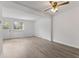Bright living room with wood-look vinyl flooring, ceiling fan, and a window overlooking a door at 3705 Lima Ct, Indianapolis, IN 46227