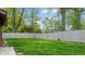 Grassy backyard, enclosed by a tall wooden privacy fence and mature trees at 4213 N Audubon Rd, Indianapolis, IN 46226