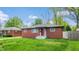 Well-maintained red brick home with a charming red front door and inviting curb appeal at 4213 N Audubon Rd, Indianapolis, IN 46226
