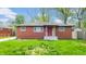 Charming brick home with a red front door, a well-maintained lawn, and ample natural light at 4213 N Audubon Rd, Indianapolis, IN 46226