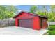 Red painted brick garage with a concrete driveway and overhead door at 4213 N Audubon Rd, Indianapolis, IN 46226