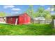 View of a detached red painted brick garage in a backyard setting at 4213 N Audubon Rd, Indianapolis, IN 46226